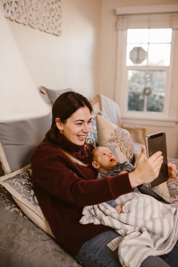 The Art of Drawing Readers In: Your attractive post title goes here Mother and baby smiling during a video call in their cozy living room setting.